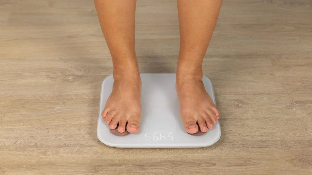 mujer pesándose en una pesa